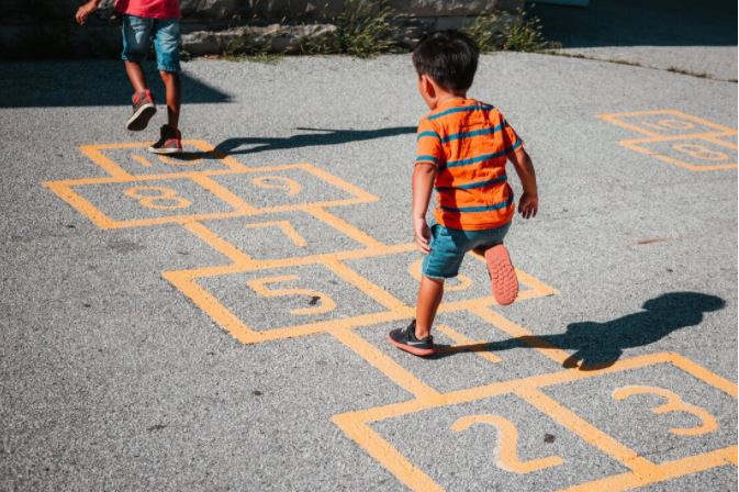 Child plays hop scotch during play time at preschool, Fort Myers